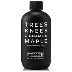Bushwick Kitchen Trees Knees Cinnamon Maple Syrup bottle on a countertop highlighting the product