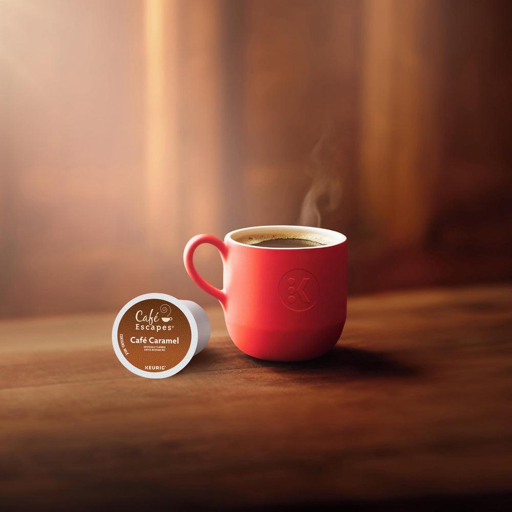 Café Escapes Café Caramel K-Cup pods pour over a steaming cup.