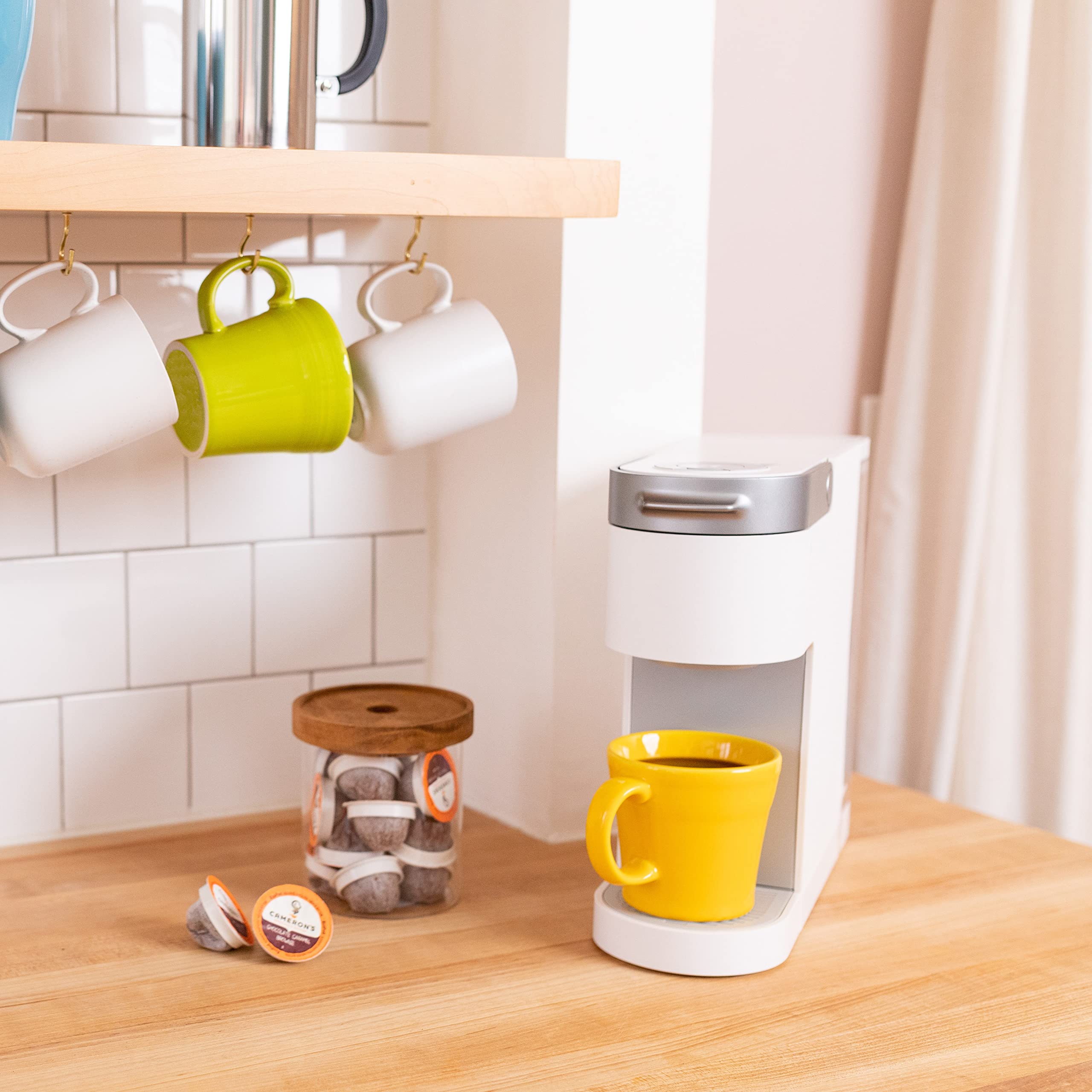 Cameron's compostable pod filter demonstrates eco-friendly coffee options for sustainable households.
