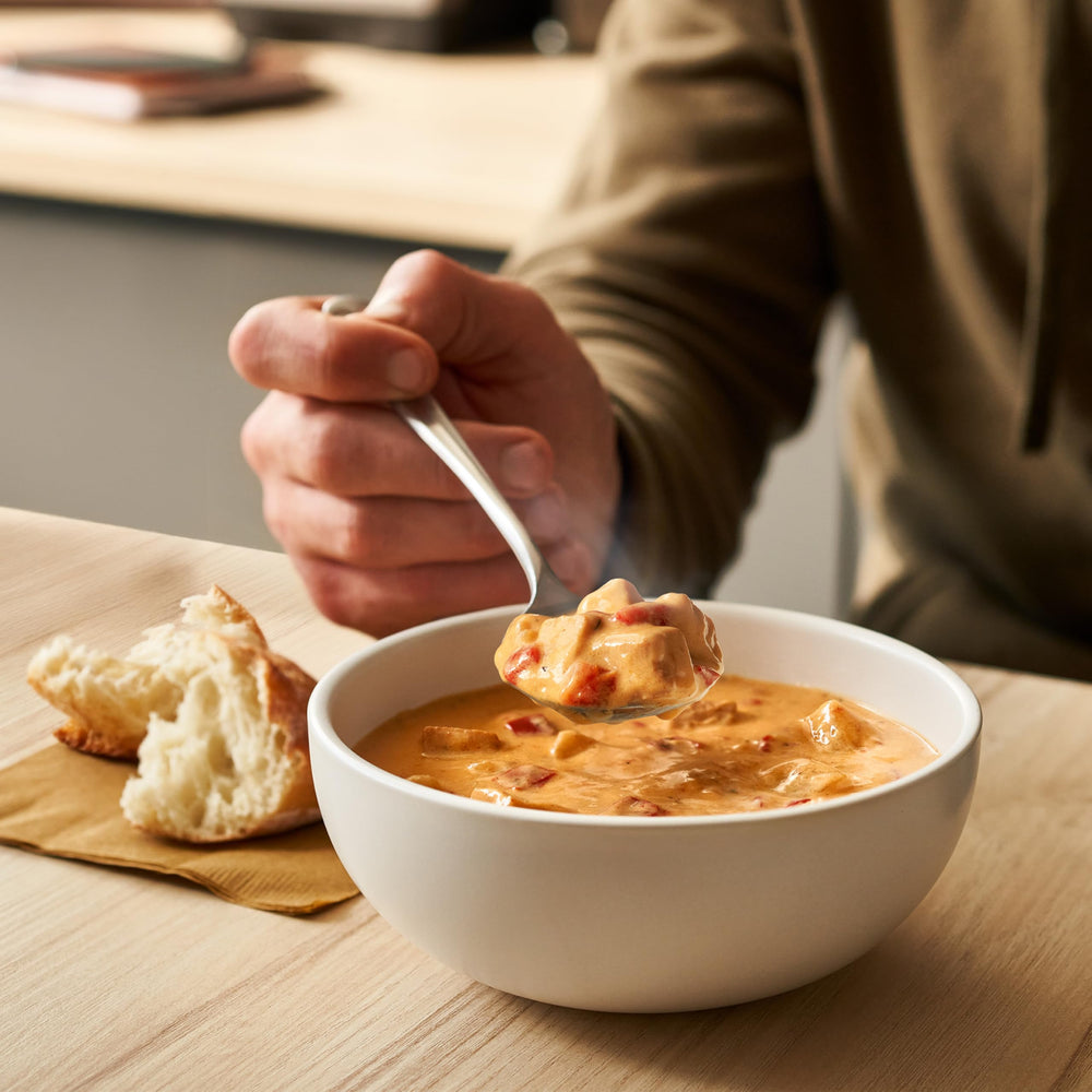 Opened can poured into bowl showing red peppers and broth in Campbell’s Chunky Spicy Nashville-Style.