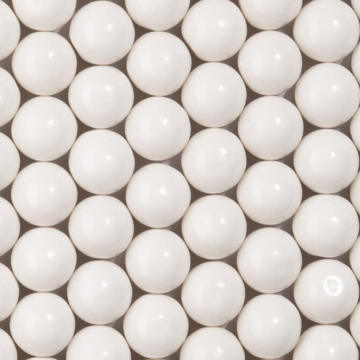 Close up view of Candy Envy white gumballs glossy texture