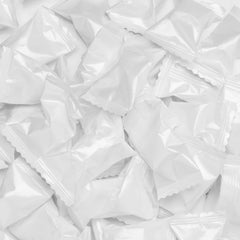 Candy Envy white-wrapped buttermints in packaging with white foil wrappers.