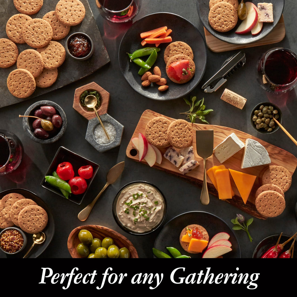 Crackers with nuts and fruits beside a charcuterie board