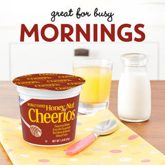 Cheerios Honey Nut cereal cup pouring milk into a bowl for a ready breakfast.