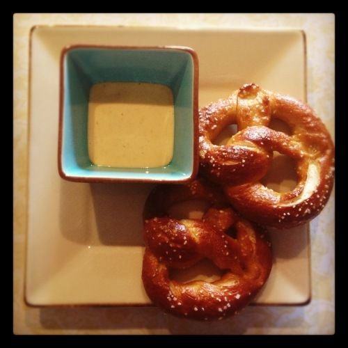 Dipping pretzels in Cherchies Champagne Mustard for a tangy snack.