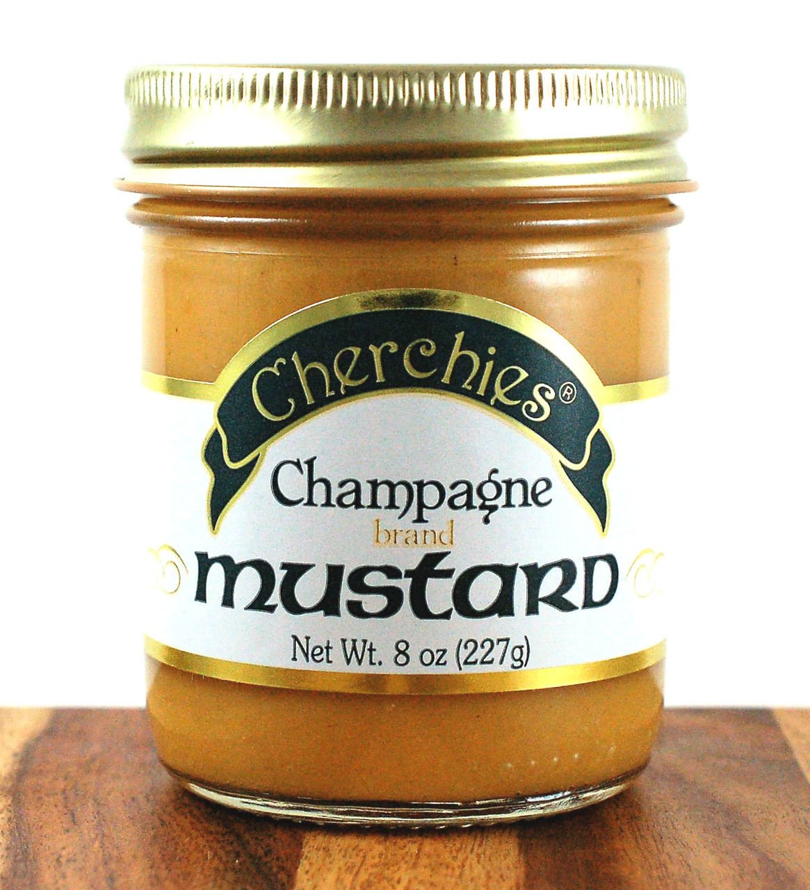 Pouring Cherchies Champagne Mustard to enrich a dish with bright tang.