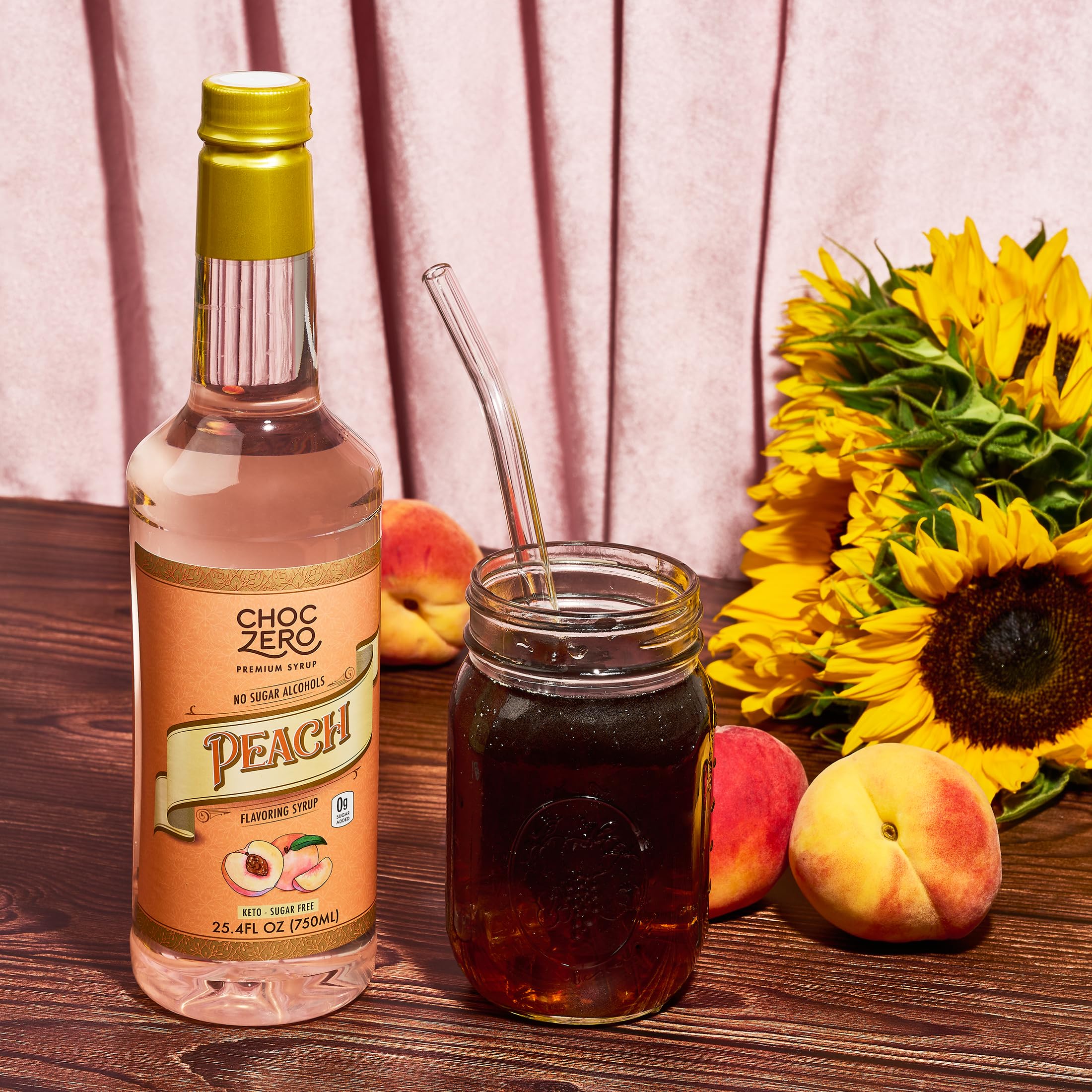 ChocZero Peach Flavoring Syrup stirring beside mug for flavor boost