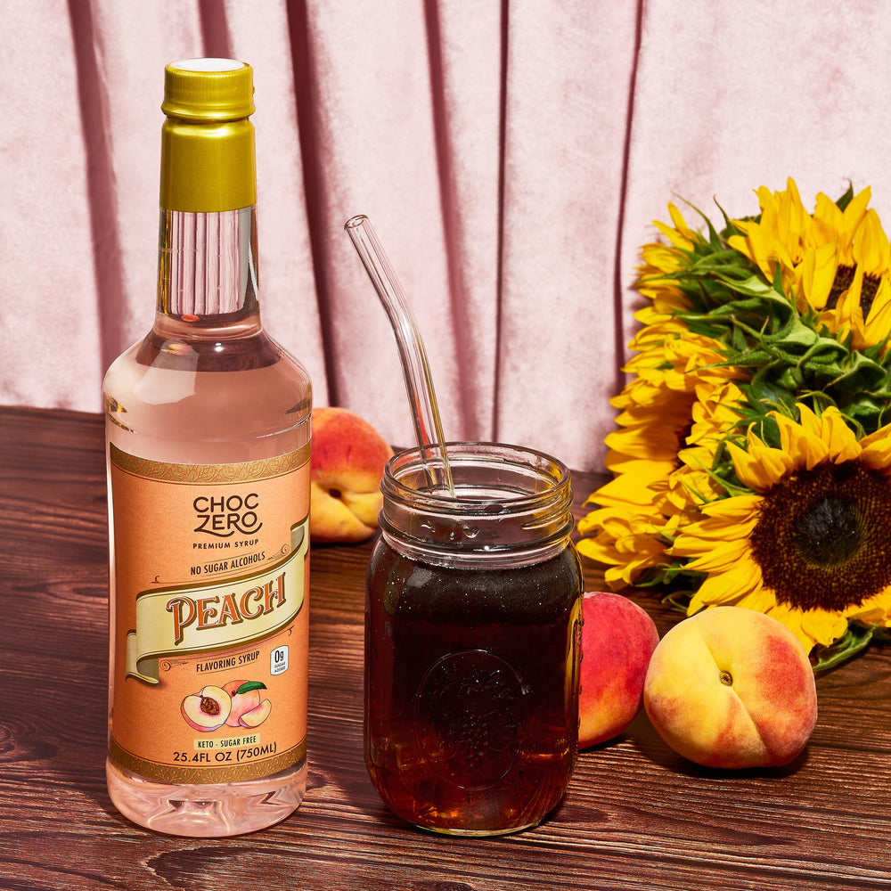 ChocZero Peach Flavoring Syrup stirring beside mug for flavor boost