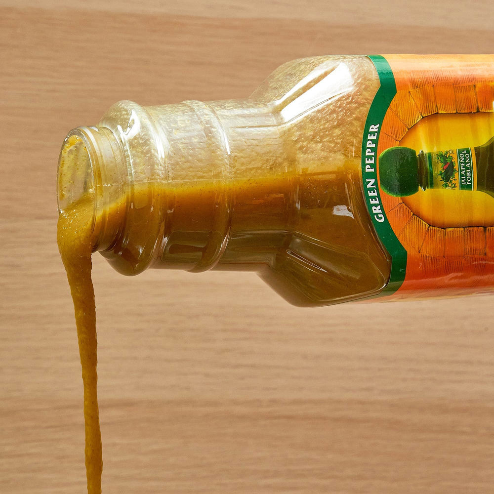 Cholula Green Pepper Hot Sauce bulk container in a restaurant prep area.