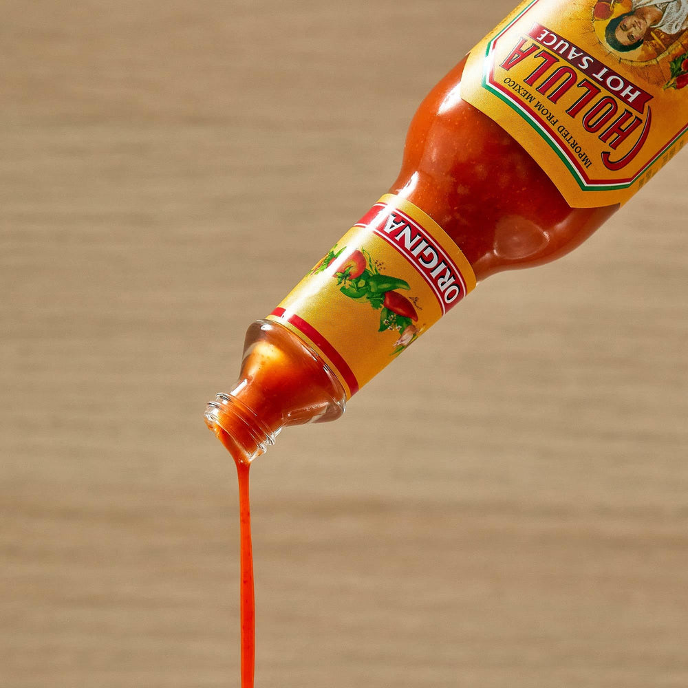 Cholula Original Hot Sauce beside nachos and a beverage ready for sharing.