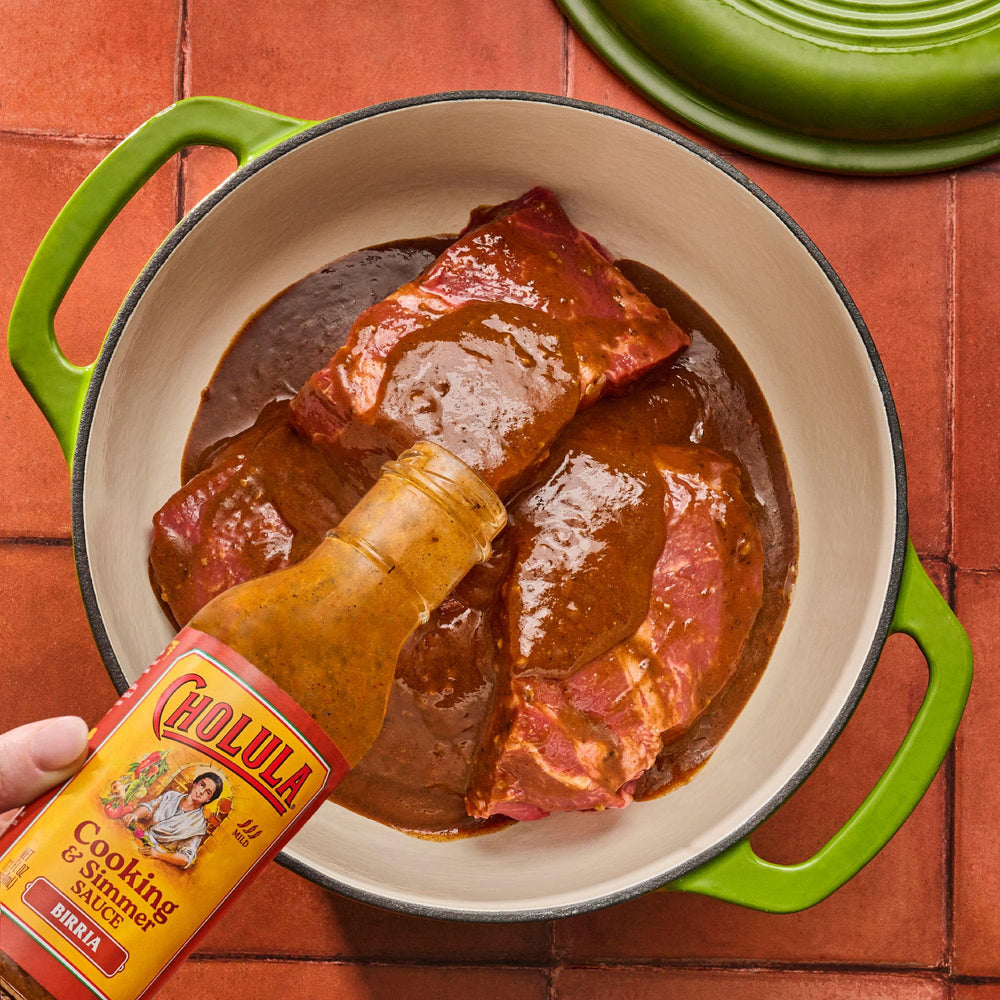 Cholula Birria tacos assembly with beef and sauce.