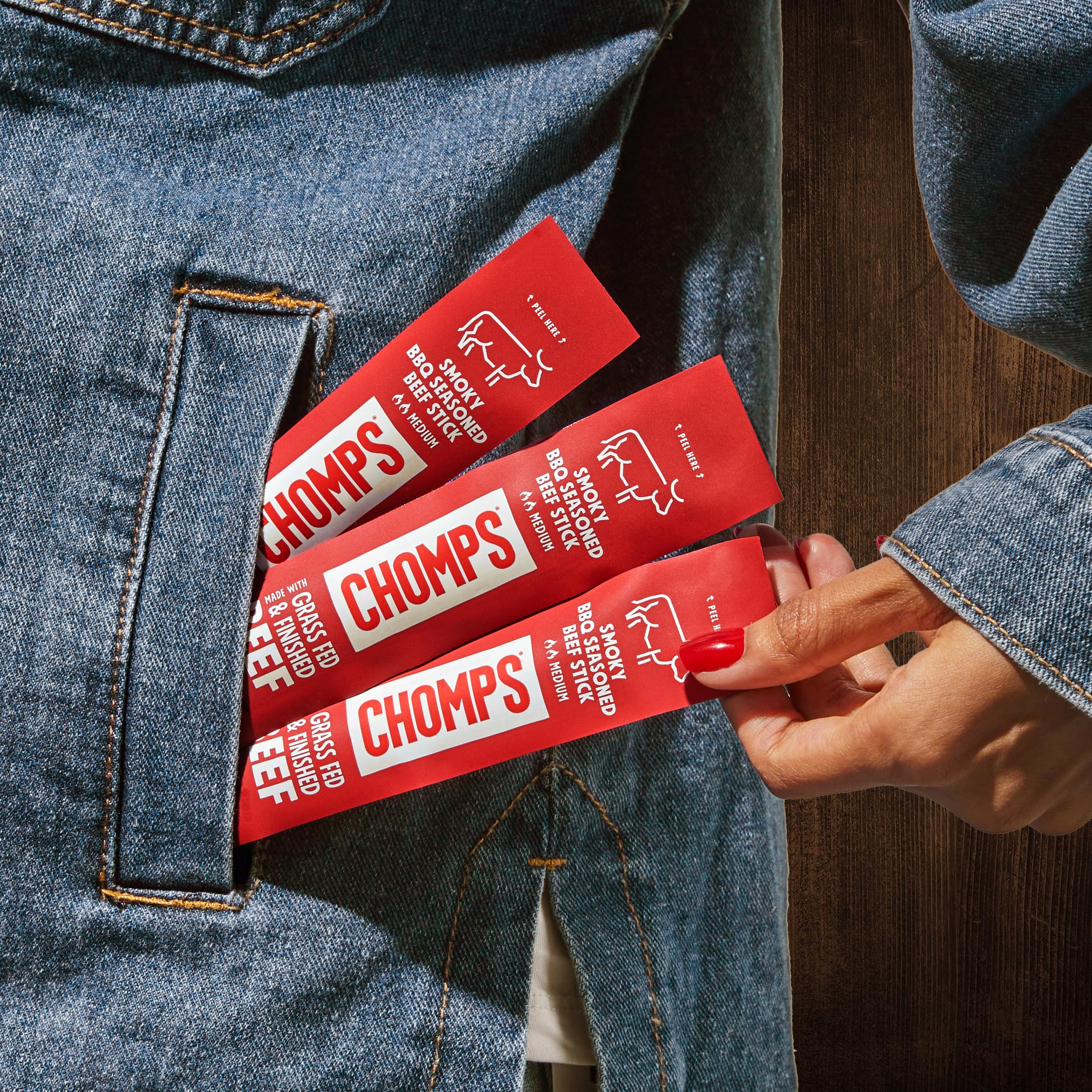 Chomps keto-friendly jerky stick in hand for quick energy.
