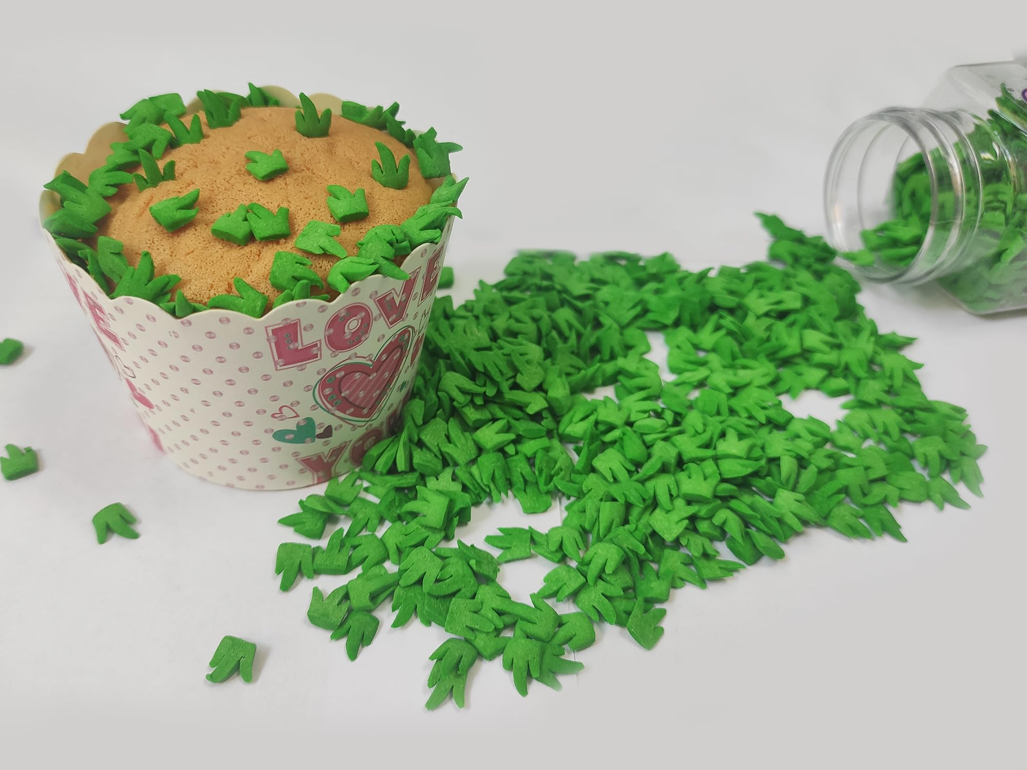 Clonynix green grass sprinkles on cupcakes for a lush finish.