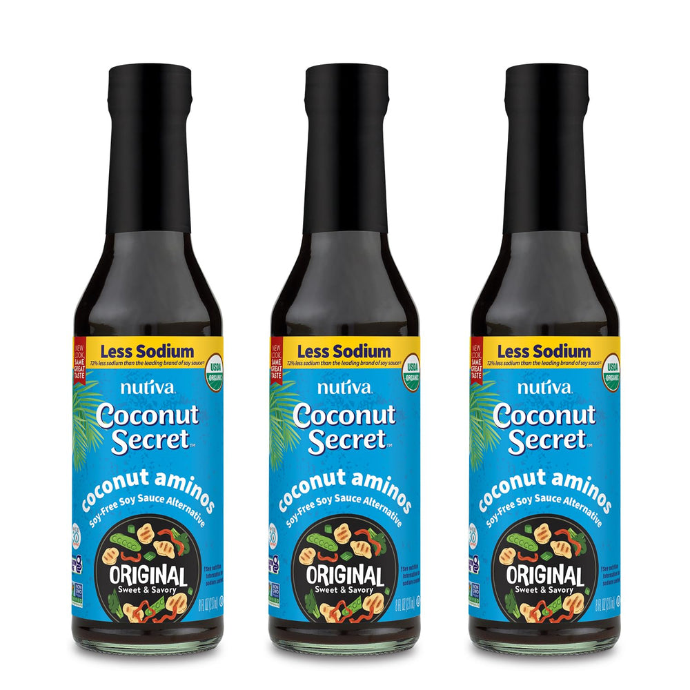 Coconut Secret Aminos bottle being poured over a stir-fry for savory umami.