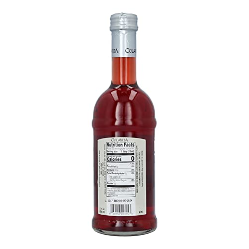 Pouring Colavita Raspberry Red Wine Vinegar over salad for tangy balance