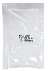 Crait maple syrup packets beside pancakes highlighting natural sweetness.