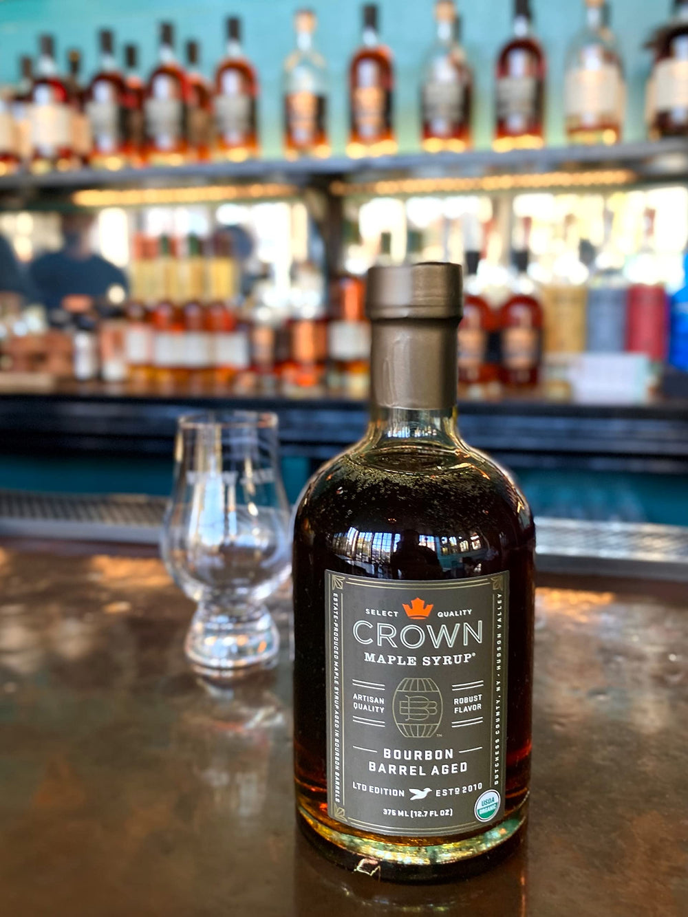 Crown Maple Bourbon Barrel Aged Syrup jar highlights sustainability and estate origin.