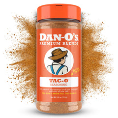 Dan-O's Tac-O Seasoning bottle pouring over sizzling meat for flavor boost
