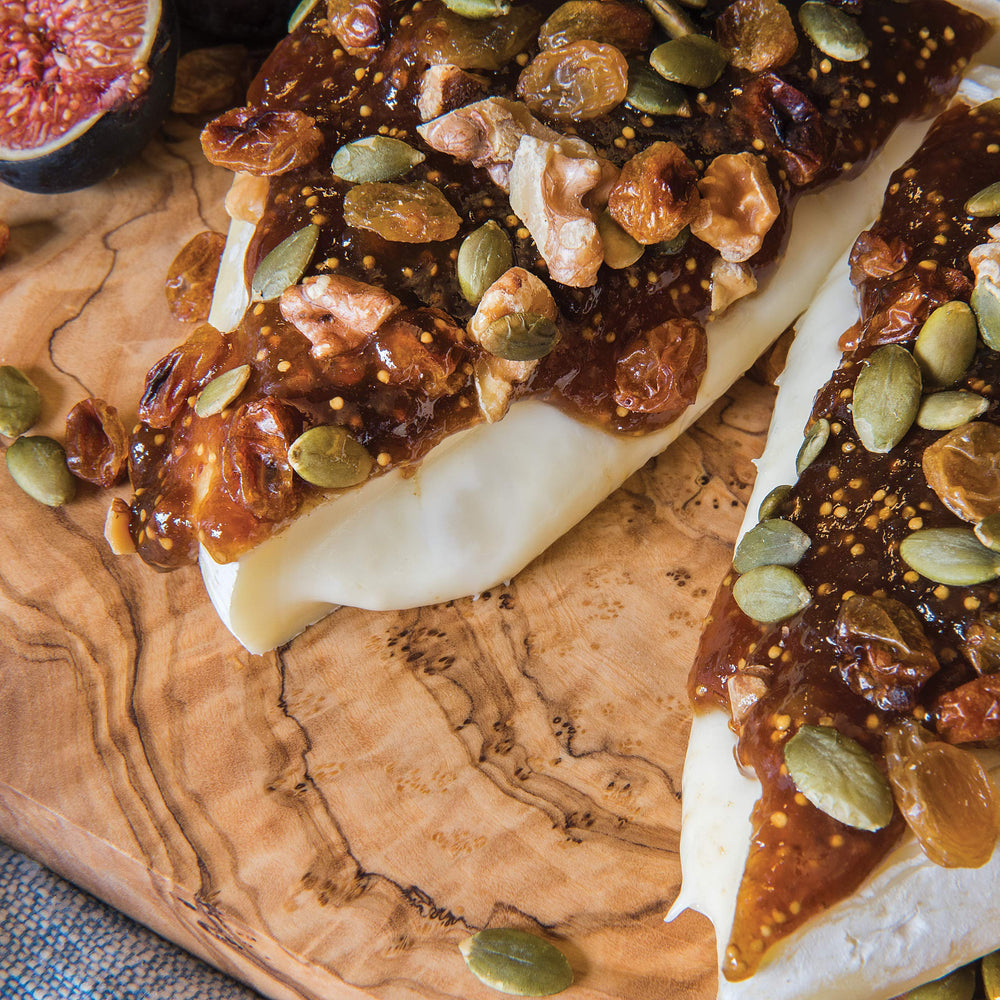 Divina fig spread on brie with walnuts, a quick appetizer idea.