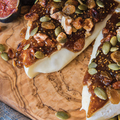 Divina fig spread on brie with walnuts, a quick appetizer idea.