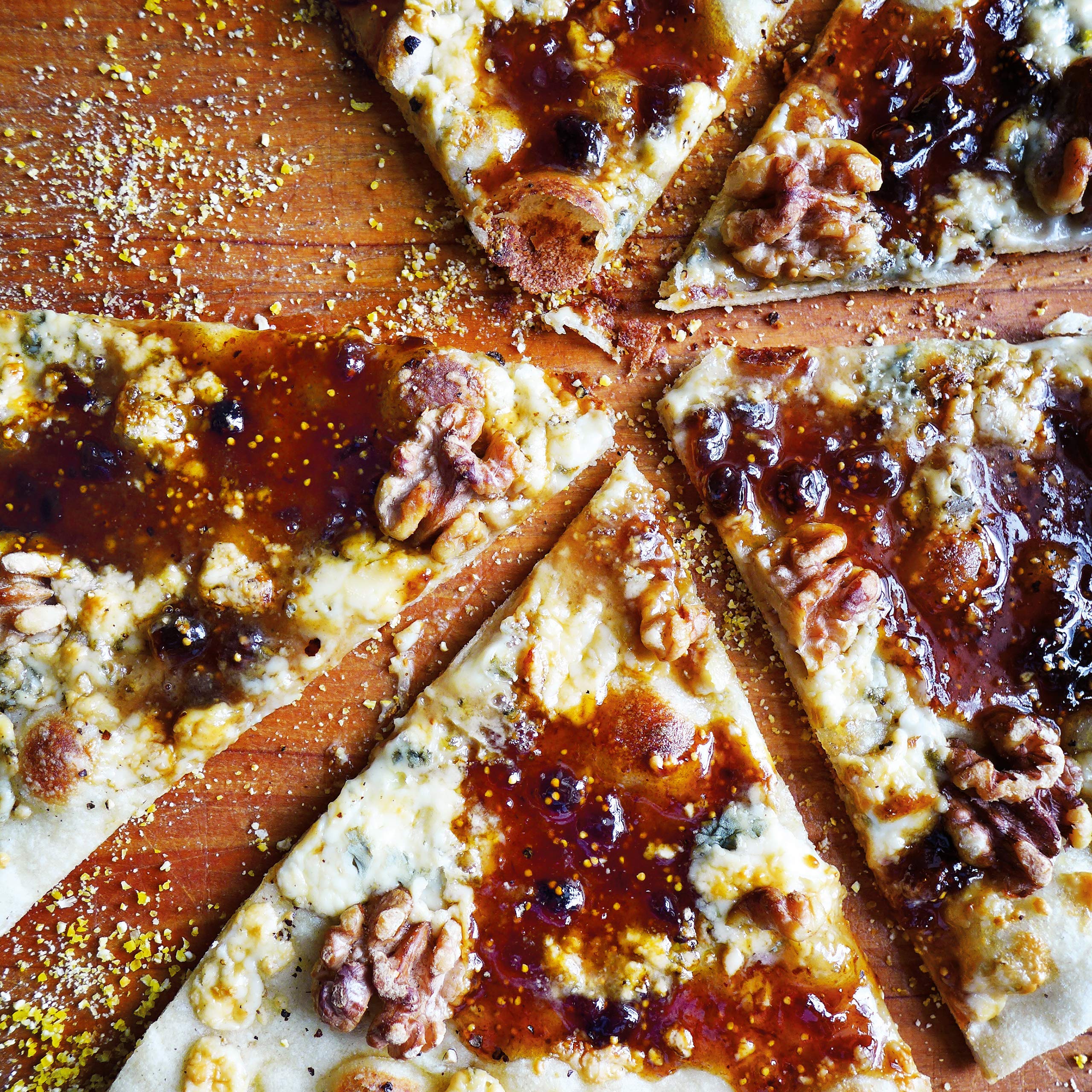 Divina fig spread atop pizza with arugula and prosciutto for flavorful bites.