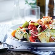 Divina Kalamata olives served as a gourmet snack beside a bottle of olive oil.