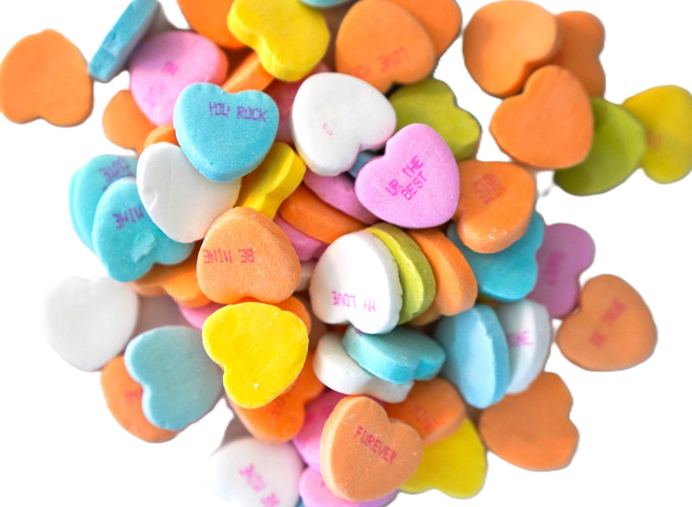 DM Sweets conversation hearts close-up shows crunchy texture and printed messages