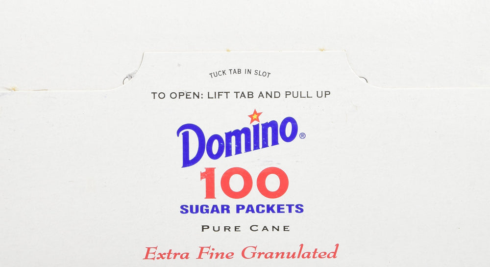 Domino sugar packets in an office breakroom for quick sugar during meetings.