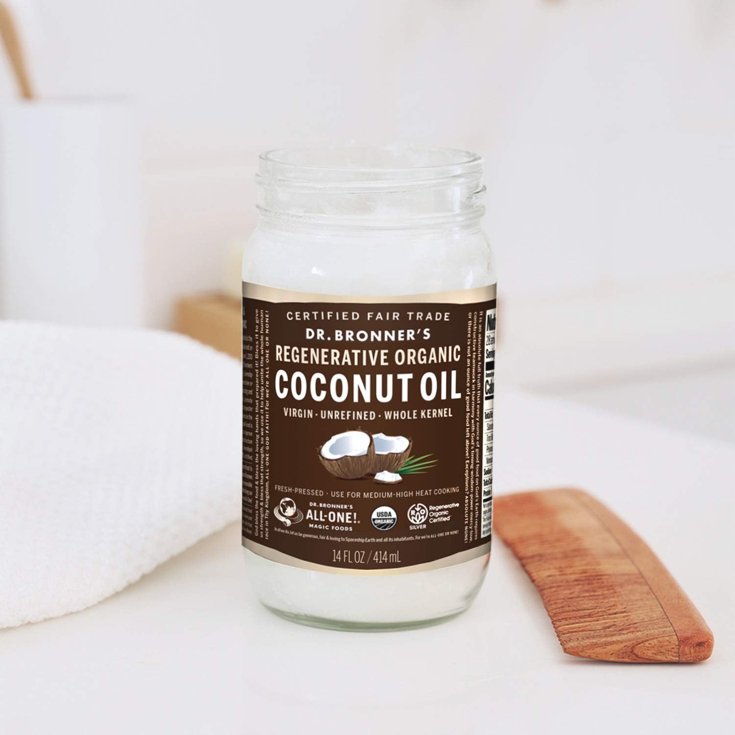 Pouring Dr. Bronner's virgin coconut oil for sautéing or baking.