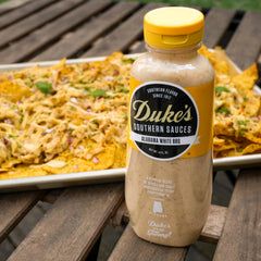 Duke's Alabama White Sauce being poured for precise serving.