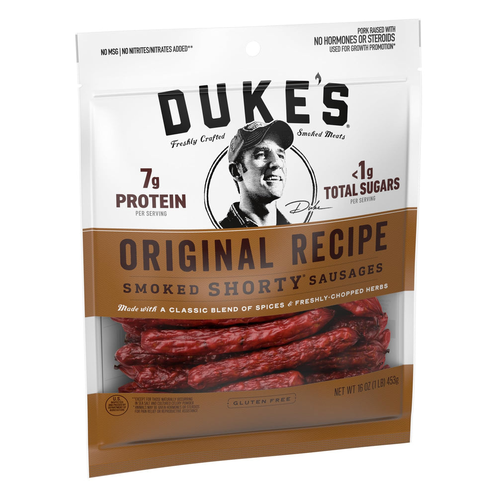 DUKE'S Pork Original Smoked Shorty Sausages grill-ready, sizzling over a fire.