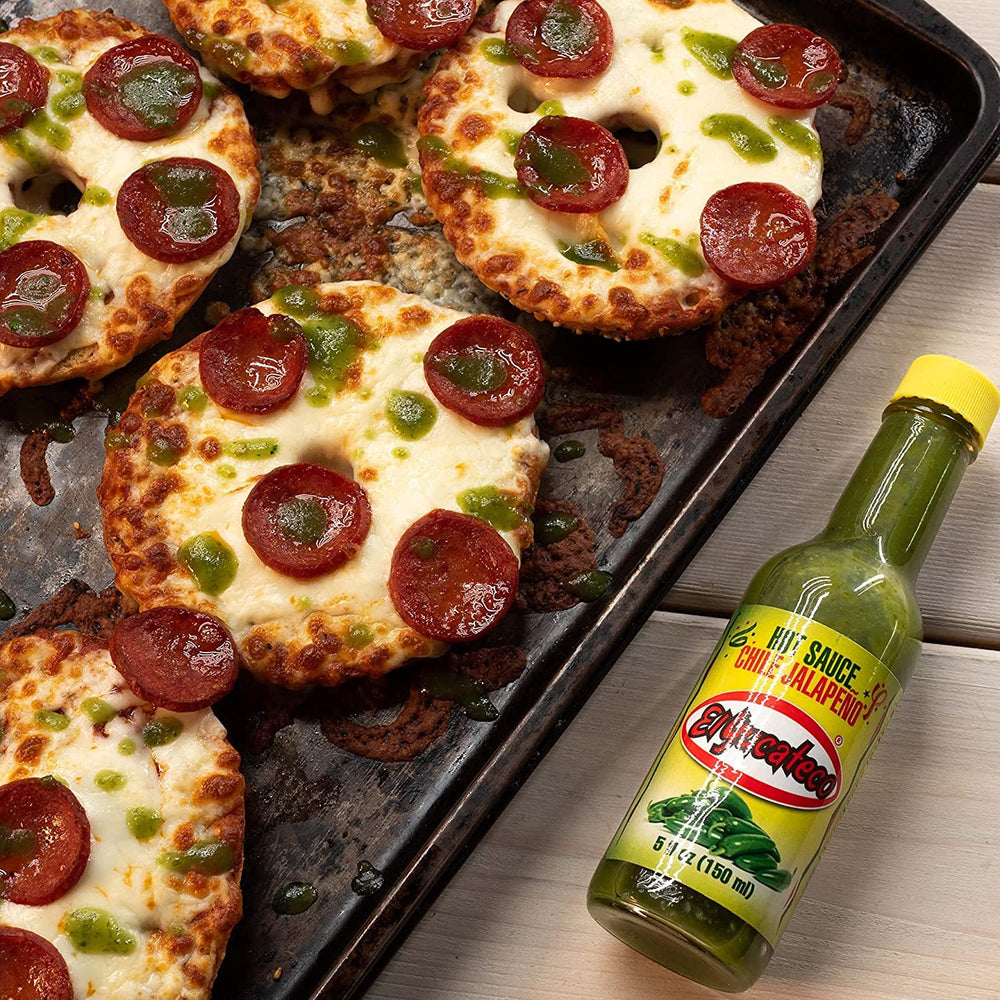 El Yucateco Jalapeno hot sauce pouring stream highlighting mild heat over a dish.