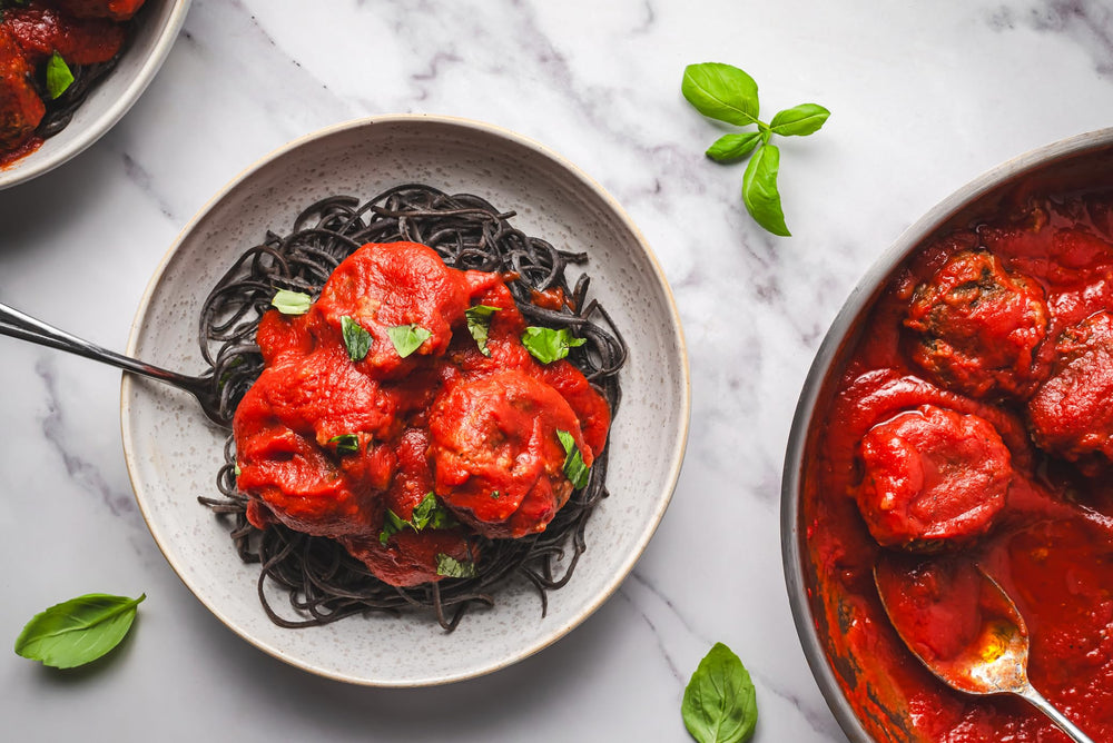 EXPLORE CUISINE Kitchen scene featuring black bean pasta.
