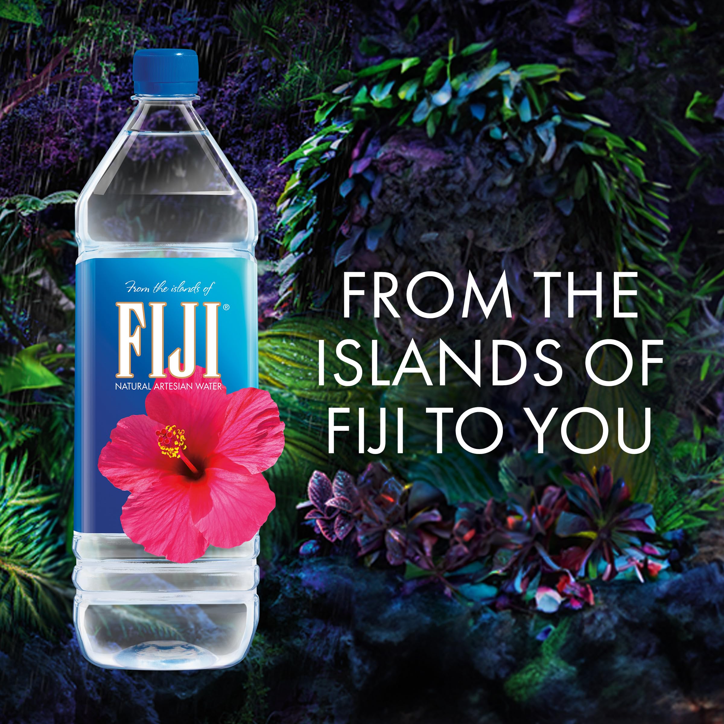 FIJI Water on a desk beside a laptop for everyday hydration at work.