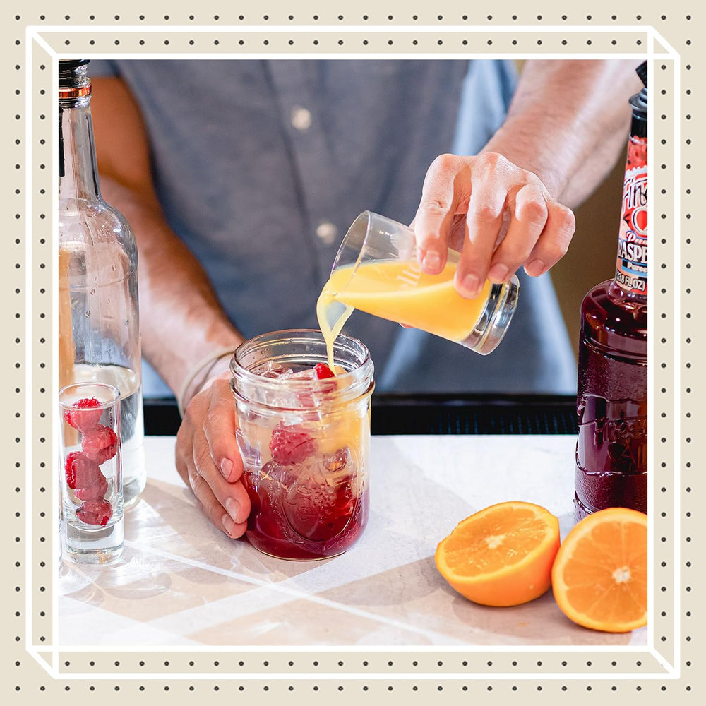 Pouring Finest Call Raspberry Puree from a glass bottle