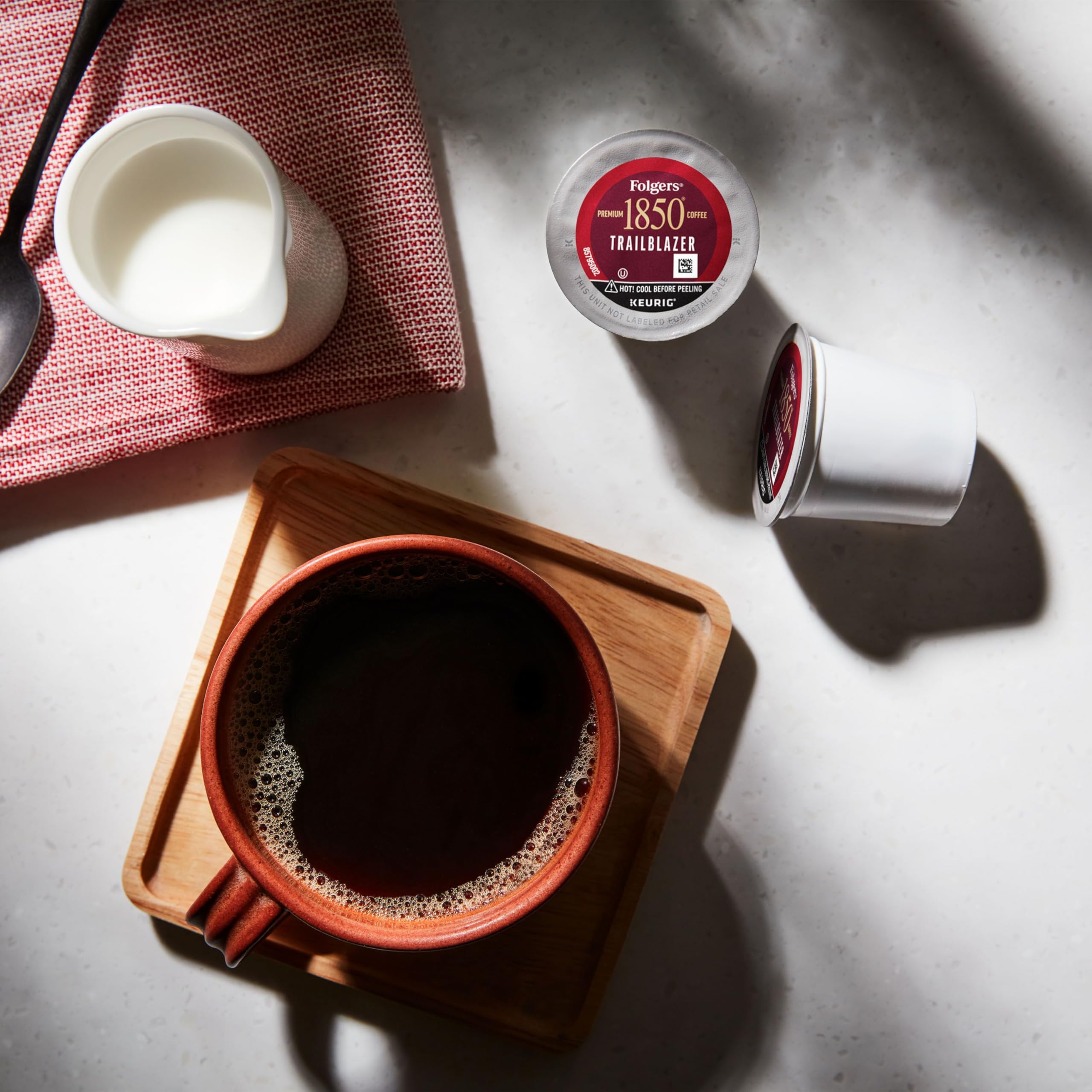 Folgers 1850 Trailblazer brewed cup steaming, signaling ready-to-drink convenience.