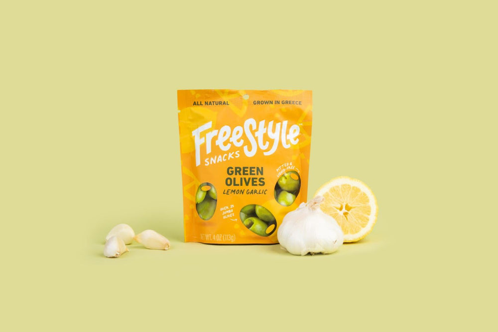 Freestyle Snacks green olives lemon garlic jar opened, convenient 4-ounce snack pack.