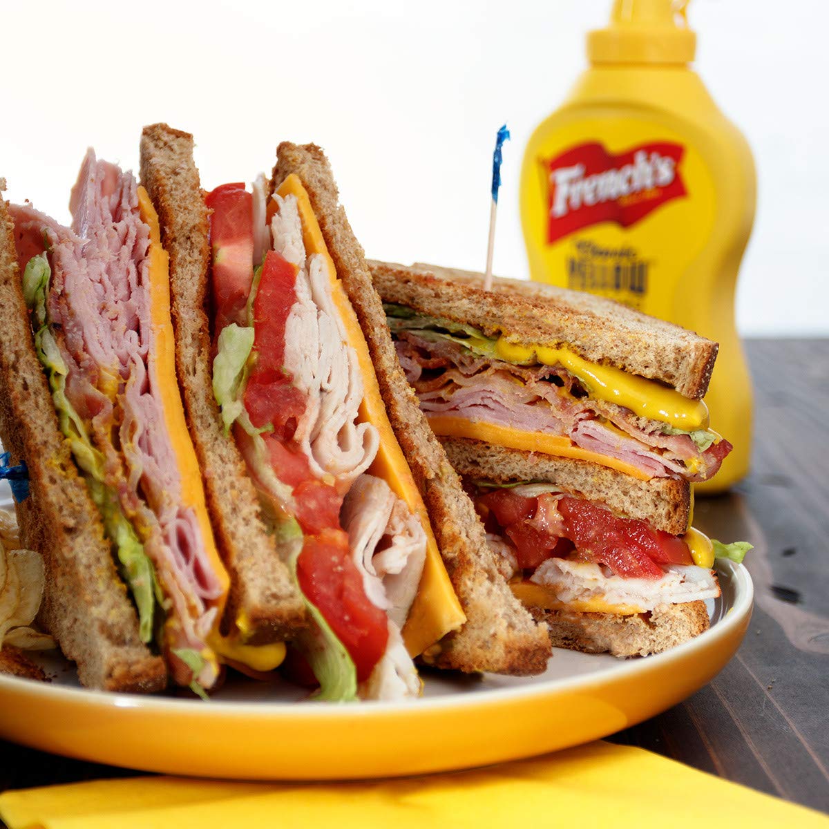 French's Yellow Mustard topping a juicy burger during a picnic.
