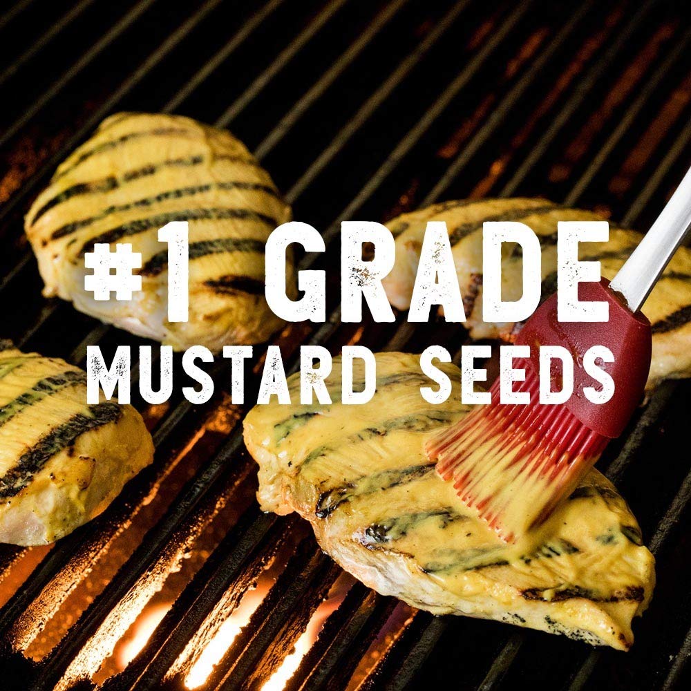 French's mustard being squeezed onto hot dogs at a barbecue.