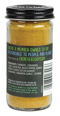 Frontier Co-op Indian Curry Seasoning poured into a hot pan for cooking.