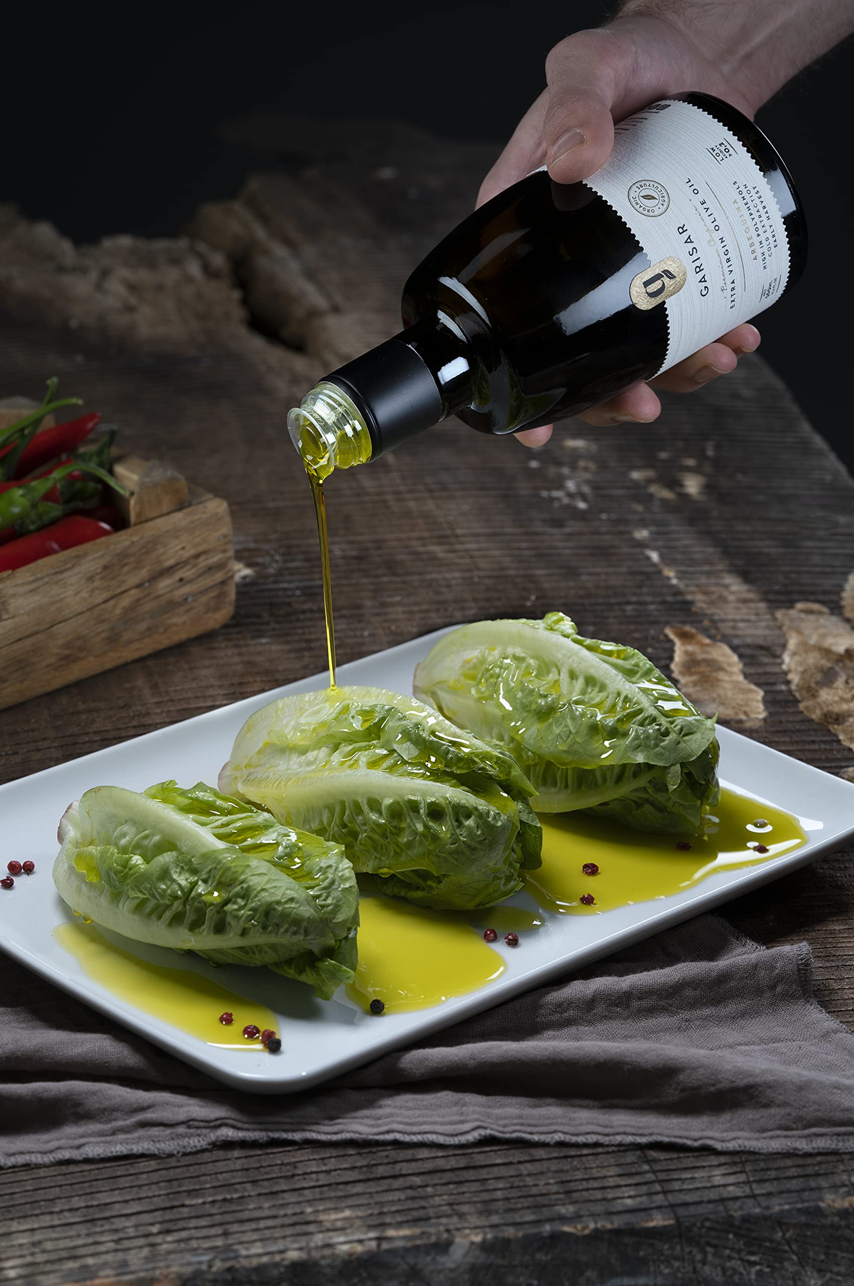 Garisar green-golden olive oil in a glass bottle ready to drizzle.