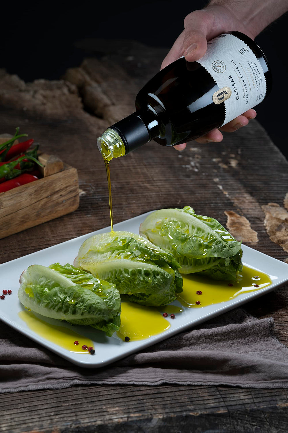 Garisar green-golden olive oil in a glass bottle ready to drizzle.