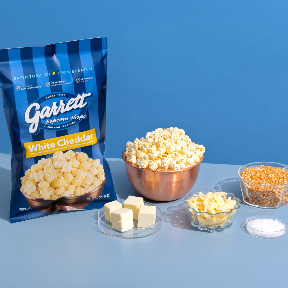 Close-up shows Garrett Popcorn White Cheddar's glossy cheese dust.