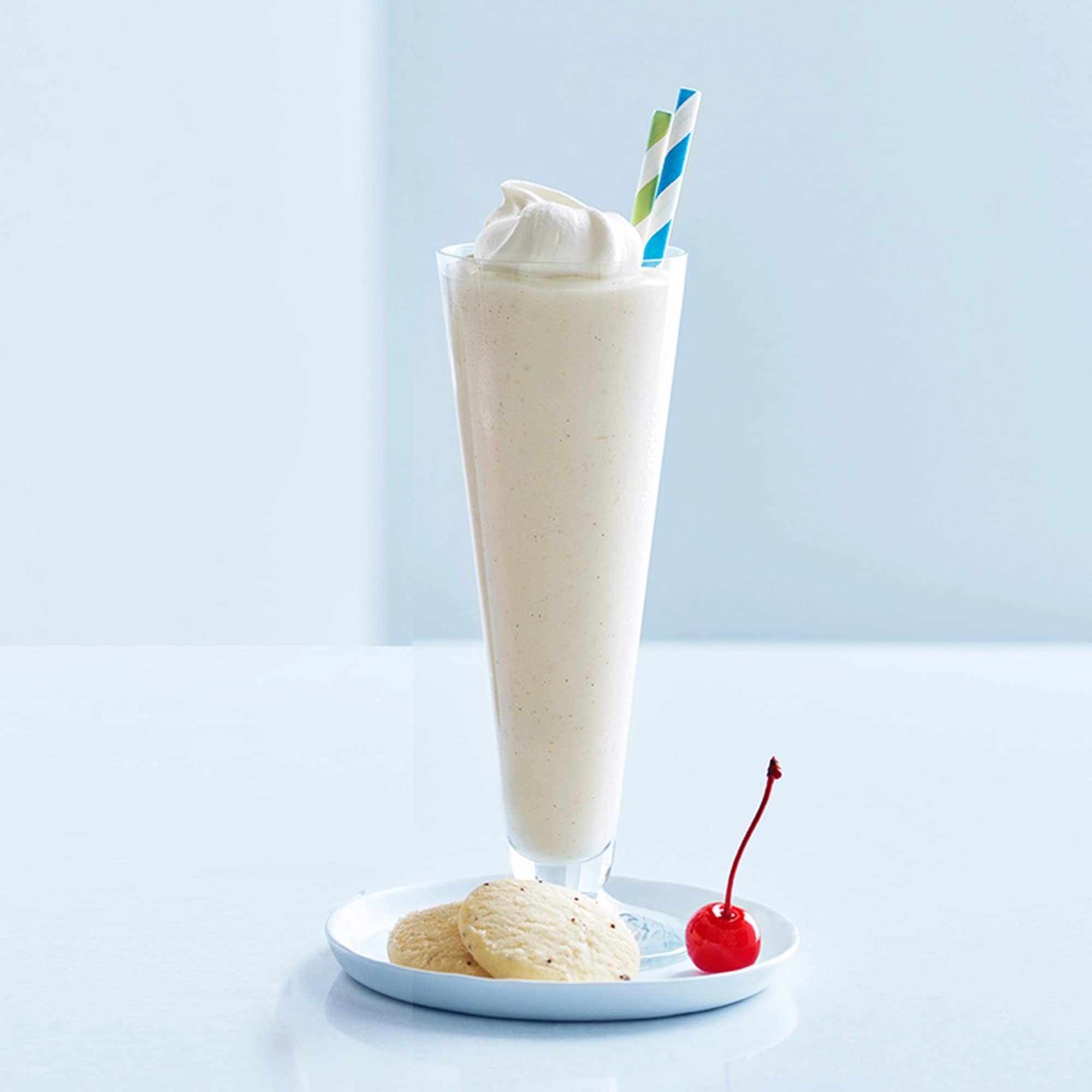 Serving a foamy white frappe in a glass featuring Ghirardelli