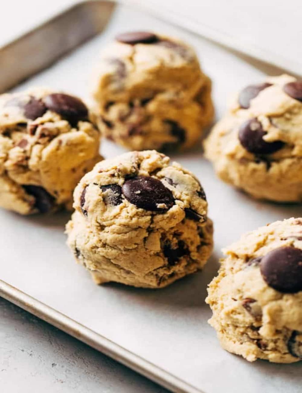 Ghirardelli baked cookies on plate, framing glossy chocolate centers.