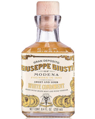 Giusti White Balsamic Dressing bottle pouring over salad for bright finish