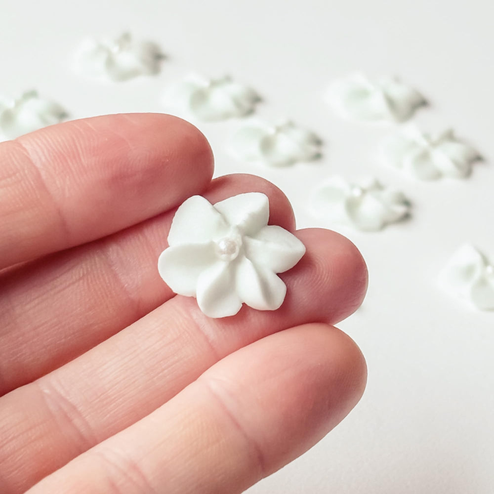 Global Sugar Art mini royal icing flowers in white with pearls for elegant wedding cupcakes.