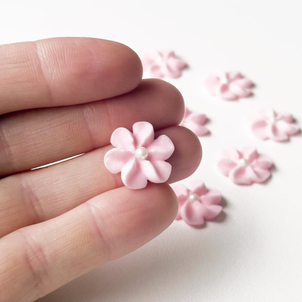 Global Sugar Art mini edible royal icing flowers with white pearl centers for elegant desserts.