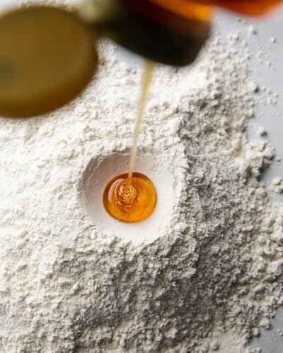 Golden Blossom Honey with wooden spoon ready for kitchen drizzle.