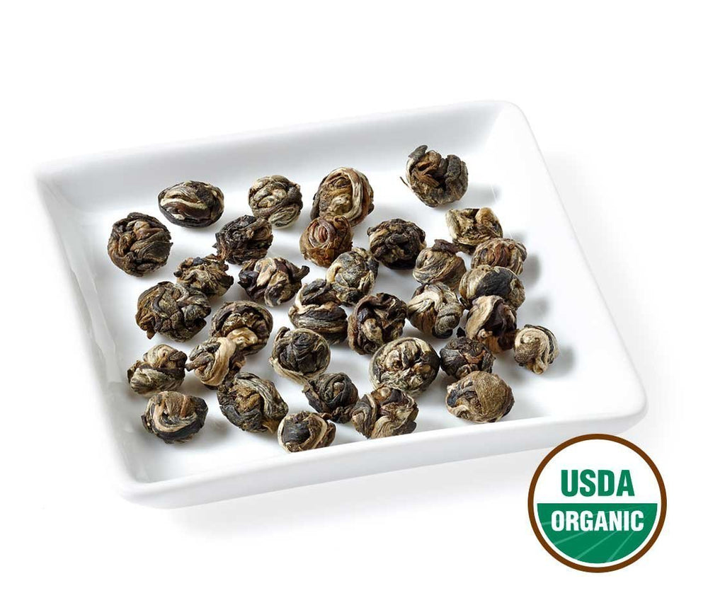 Golden Moon Tea Jasmine Dragon Pearls steeping; cup reveals smooth mellow green base.